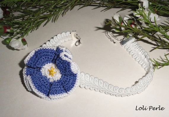 Blått blomsterhalsband på vit flätning