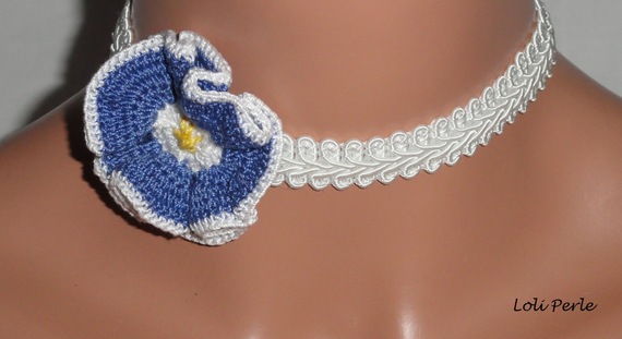 Blått blomsterhalsband på vit flätning