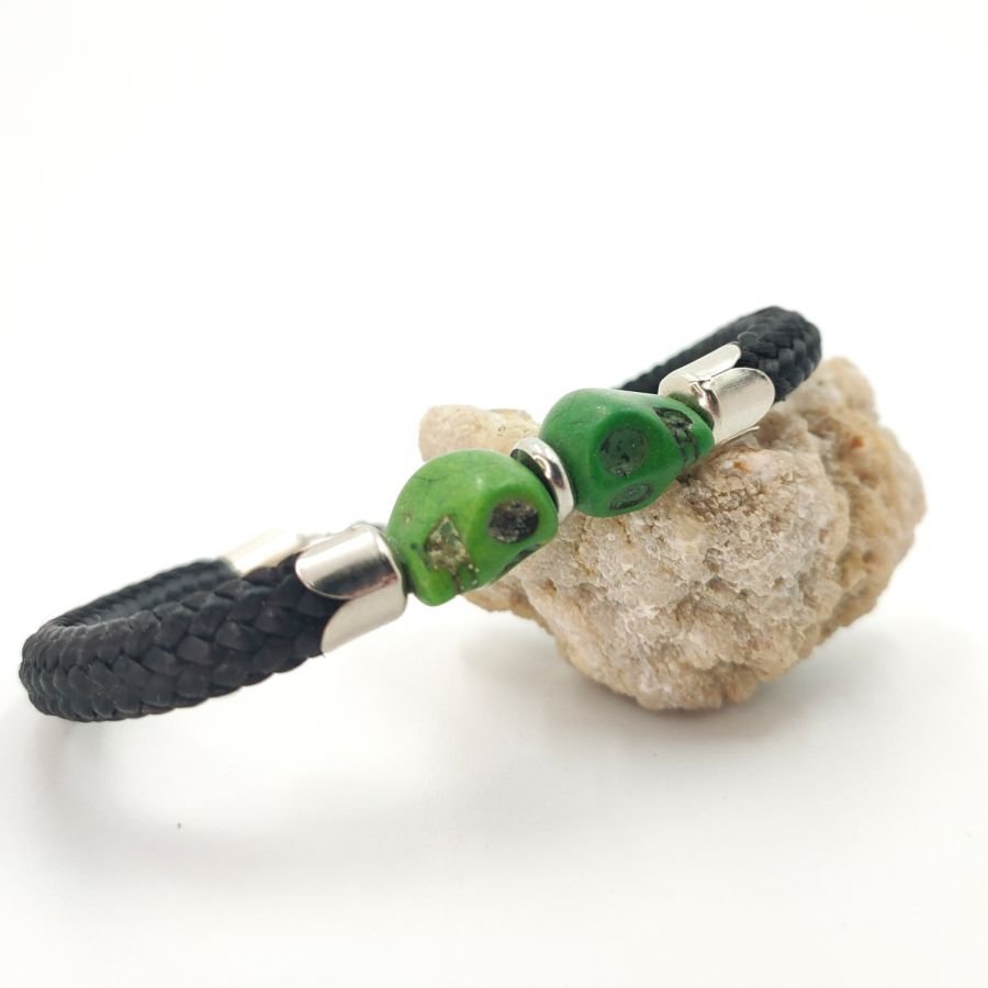 Armband med dubbla dödskallar och korsben med gröna stenar på svart rep