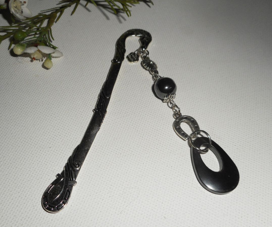 Bokmärke med liten silverhästsko och hematitstenar