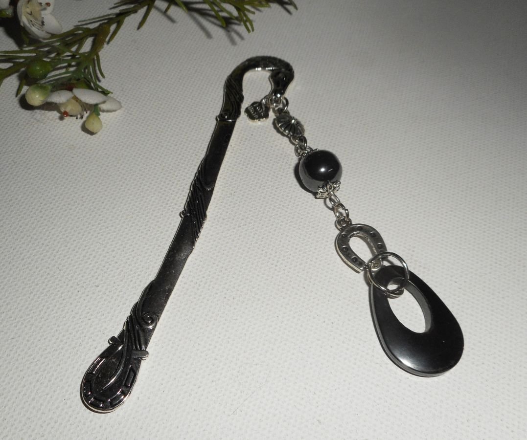 Bokmärke med liten silverhästsko och hematitstenar