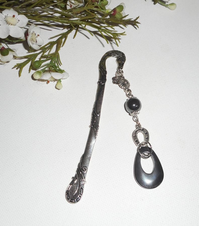 Bokmärke med liten silverhästsko och hematitstenar