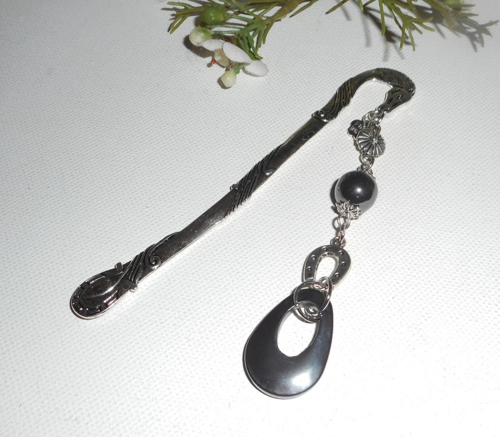 Bokmärke med liten silverhästsko och hematitstenar